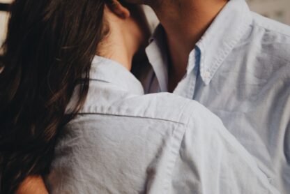 Man and woman wearing blue Oxford shirts in close proximity, romance implied