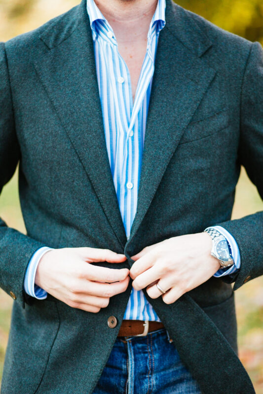 Close up eidos No Man Walks Alone emerald jacket with omega seamaster and large scale reverse stripe shirt