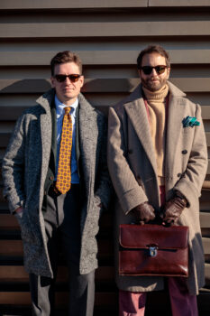 Two men at Pitti Uomo wearing a gray herringbone coat and a tan heavy twill double breasted coat